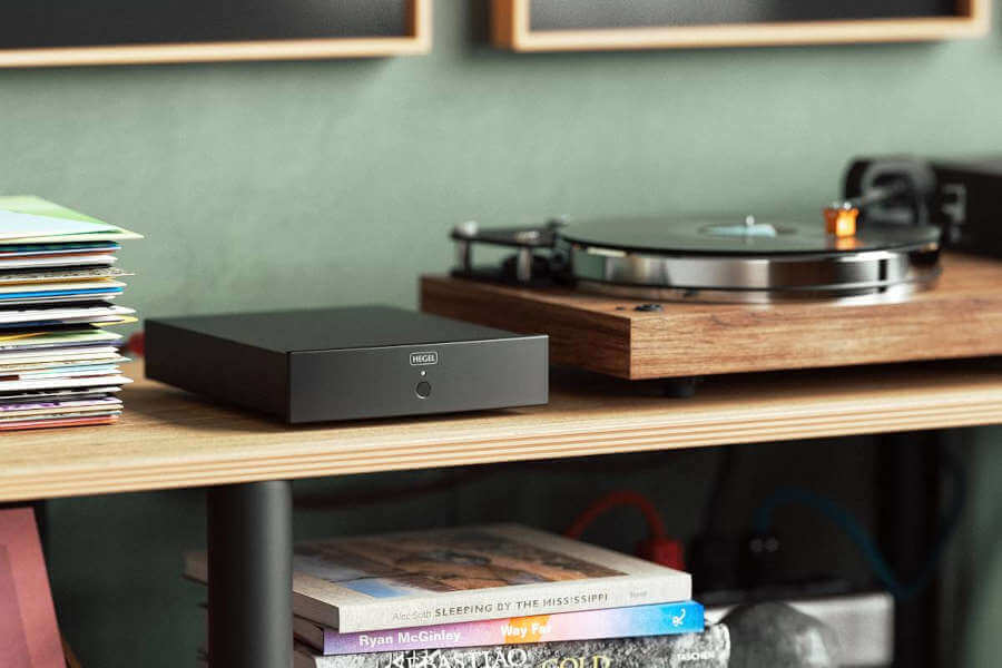 Amplificateur Hegel v10 mis en situation sur un meuble avec une platine vinyle