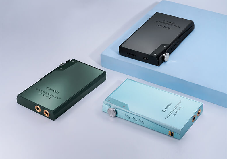 Trois lecteurs audio numériques iBasso DX180 en vert, noir et bleu disposés sur une surface.