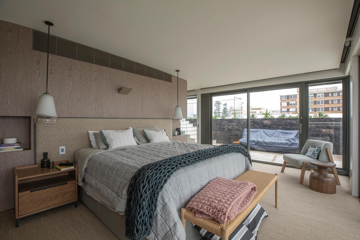 Penthouse bedroom with a large bed and glazed wall