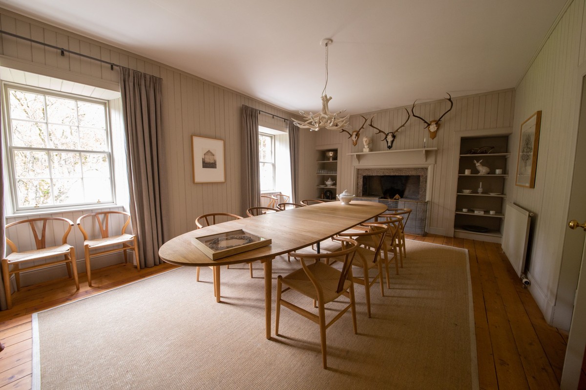 Panelled dining room with a wooden table and fireplace