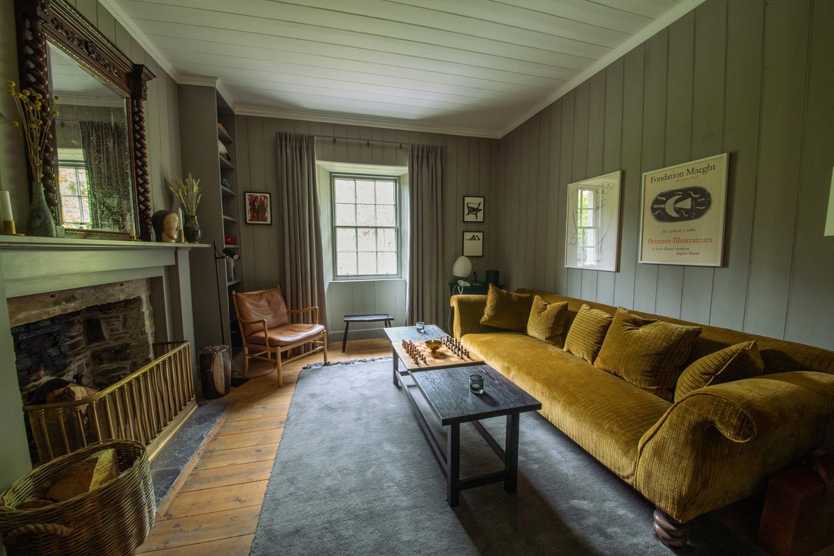 Panelled living room with a velvet sofa and fireplace