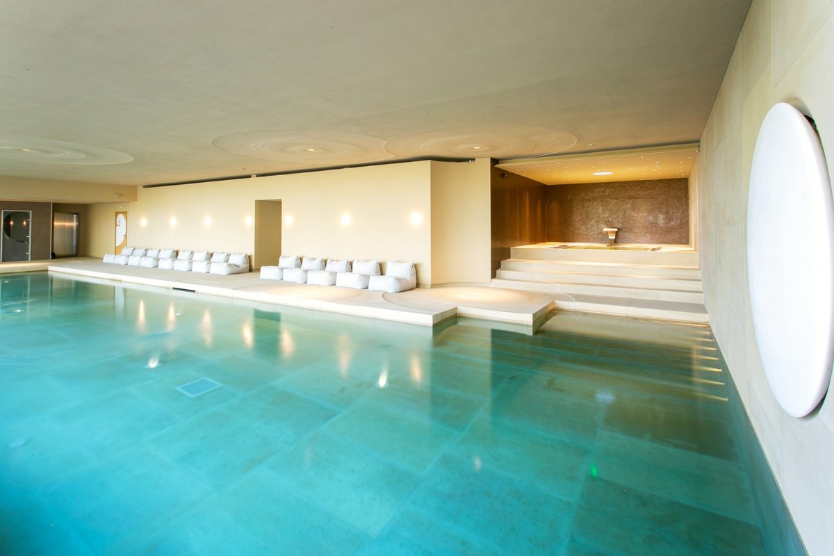 Indoor pool with plastered walls and a round window