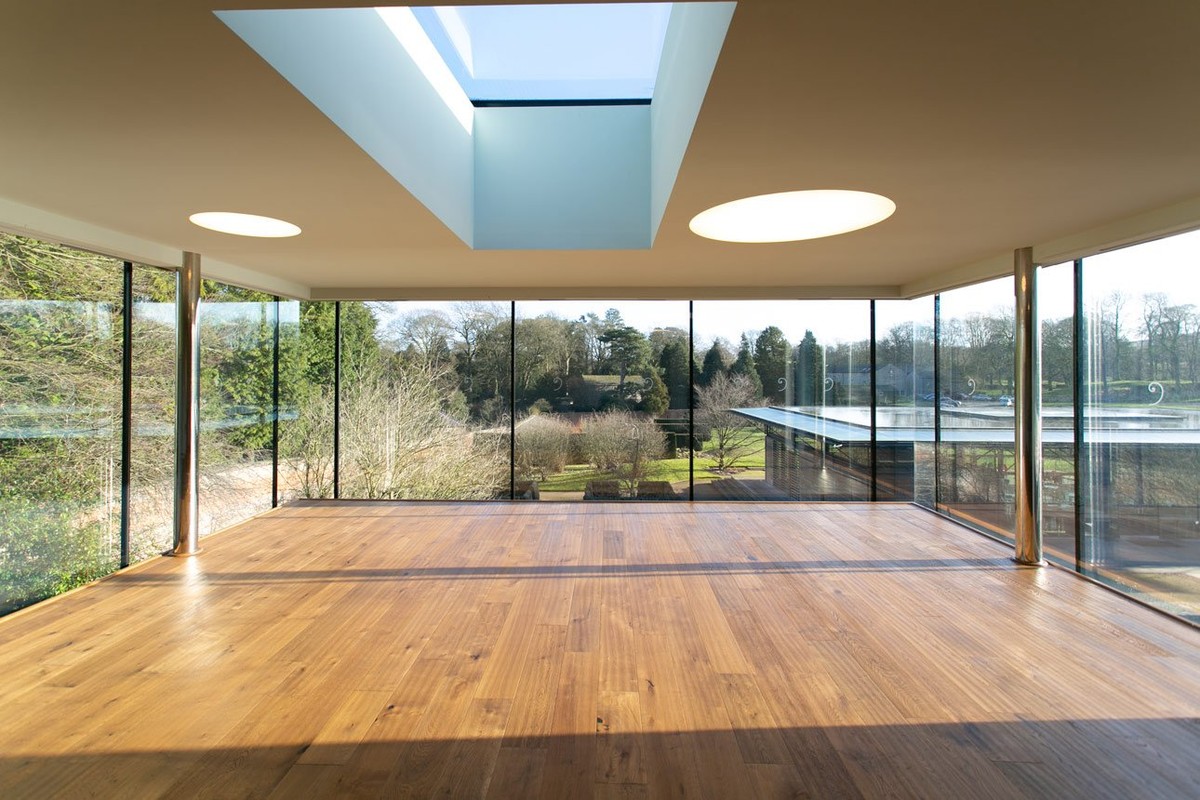 Sunlit studio with wooden floor and full-height glazing