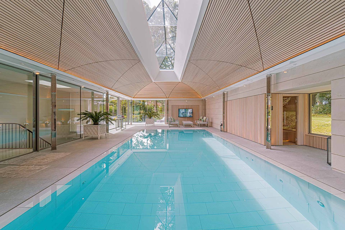 Piscine intérieure sous un plafond en lattes de bois