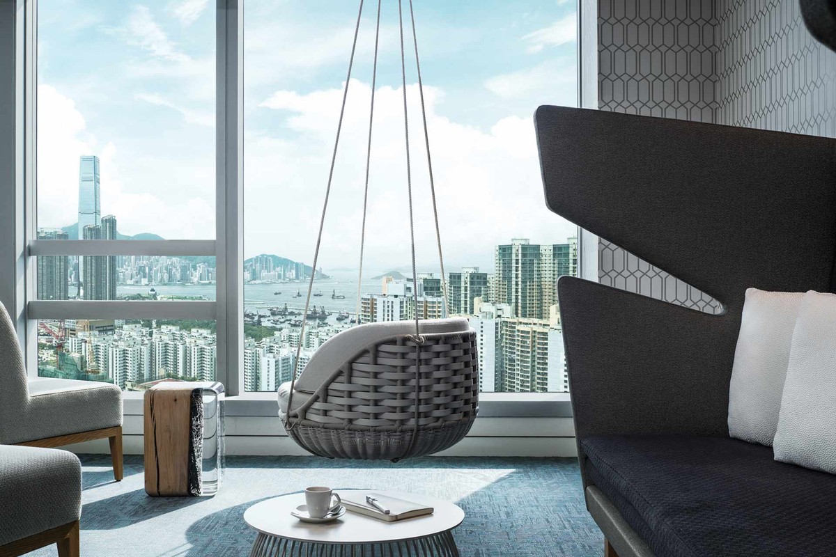 Salon de club-house avec fauteuil suspendu et vue urbaine
