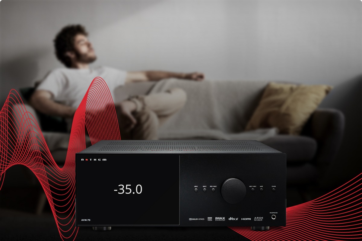 Relaxed man on a sofa in front of a black A/V processor surrounded by red sound waves