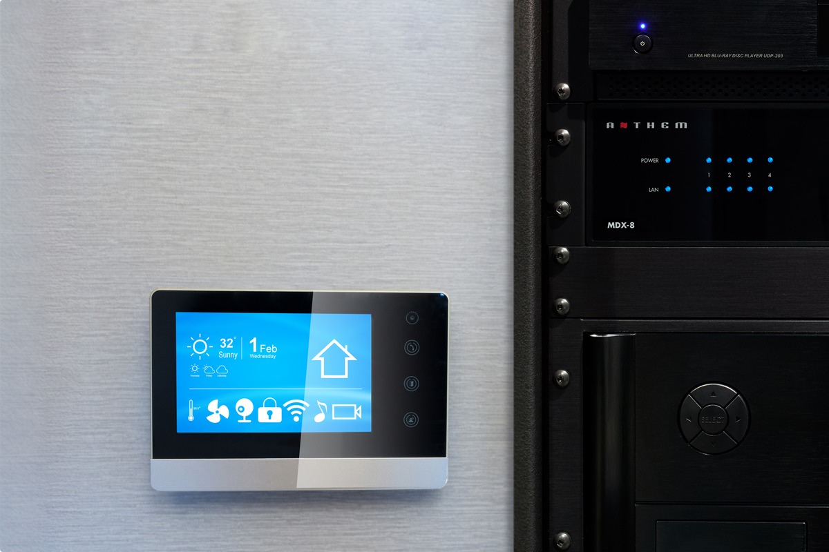 Wandmontierter Touchscreen neben einem Rack mit Elektronik