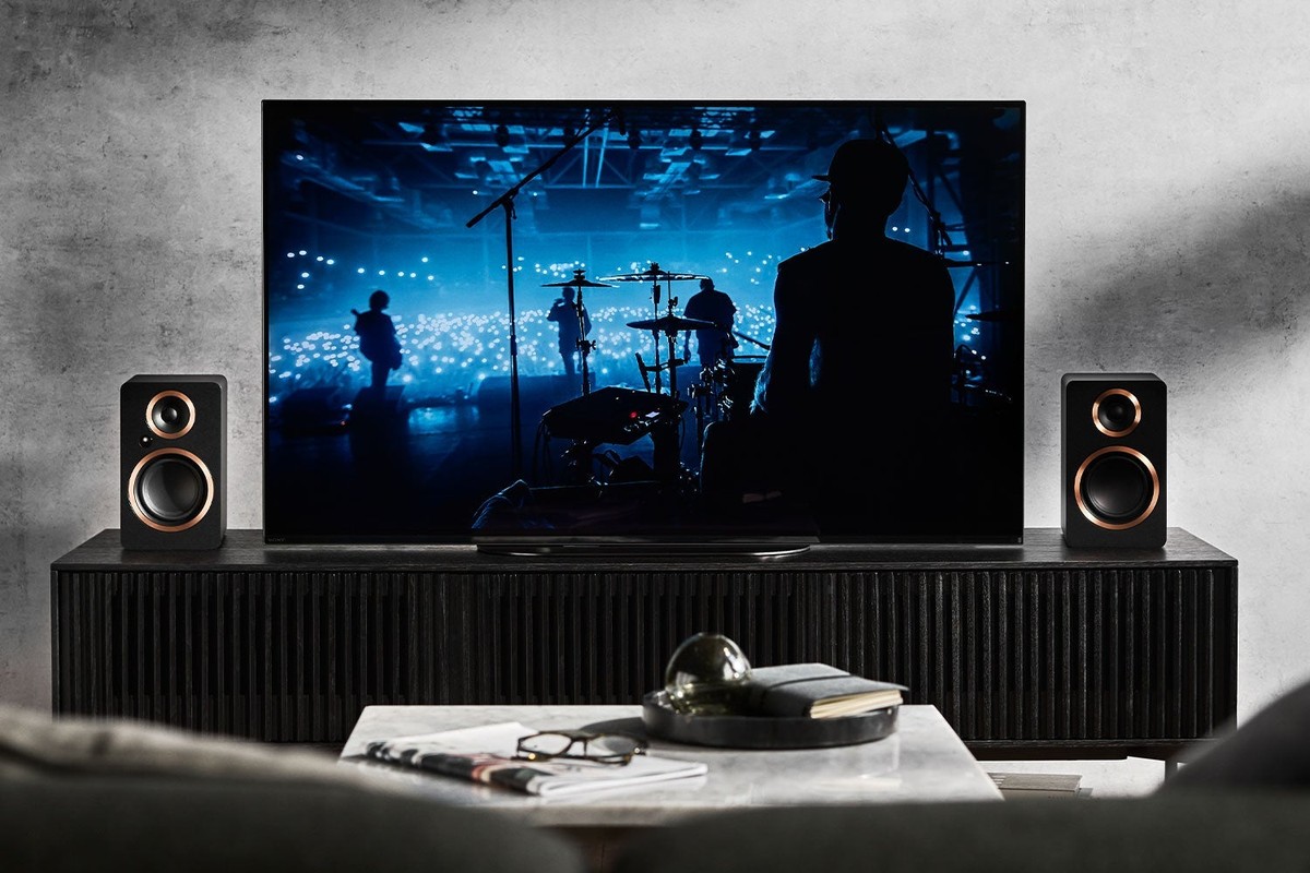 Coppia di diffusori neri su un mobile TV ai lati del televisore
