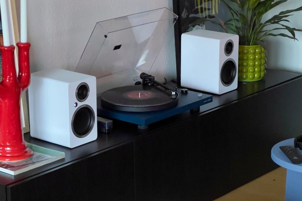 Diffusori bianchi su una credenza accanto a un giradischi