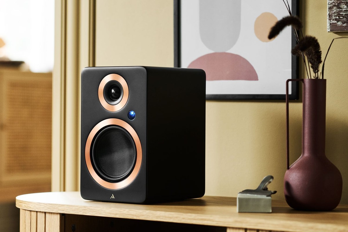 Diffusore nero con anelli color rame su un mobile in legno chiaro