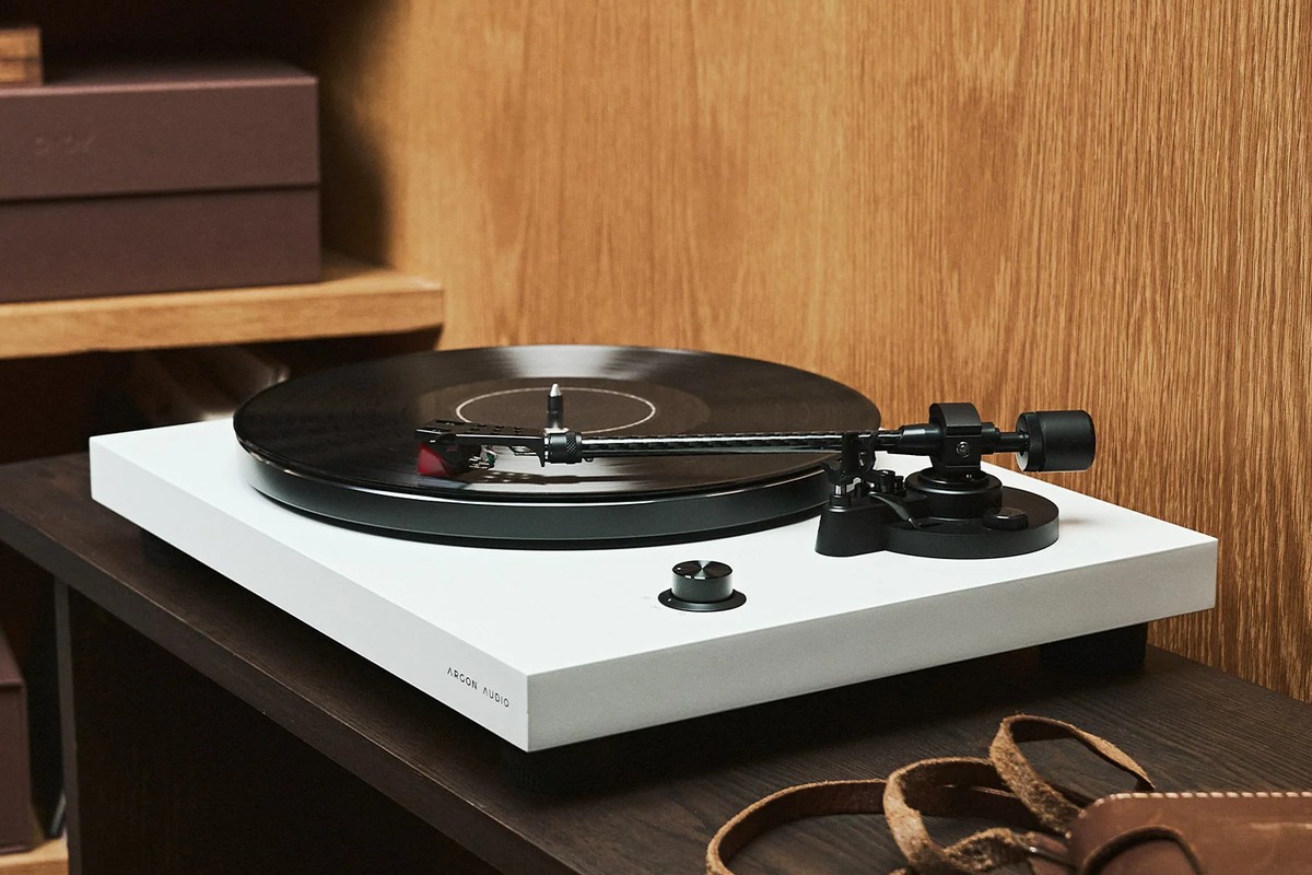 Platine blanche avec un disque sur un meuble sombre