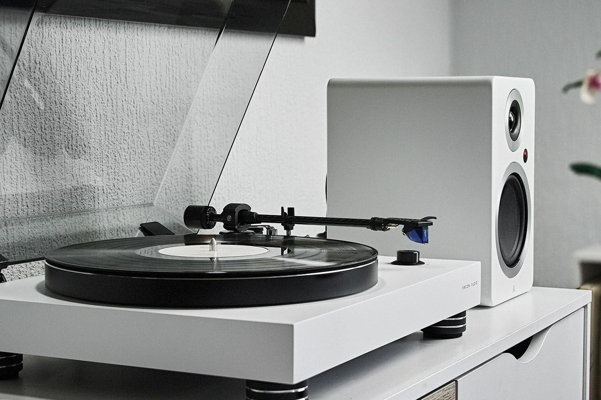 White turntable next to a white speaker in a living room