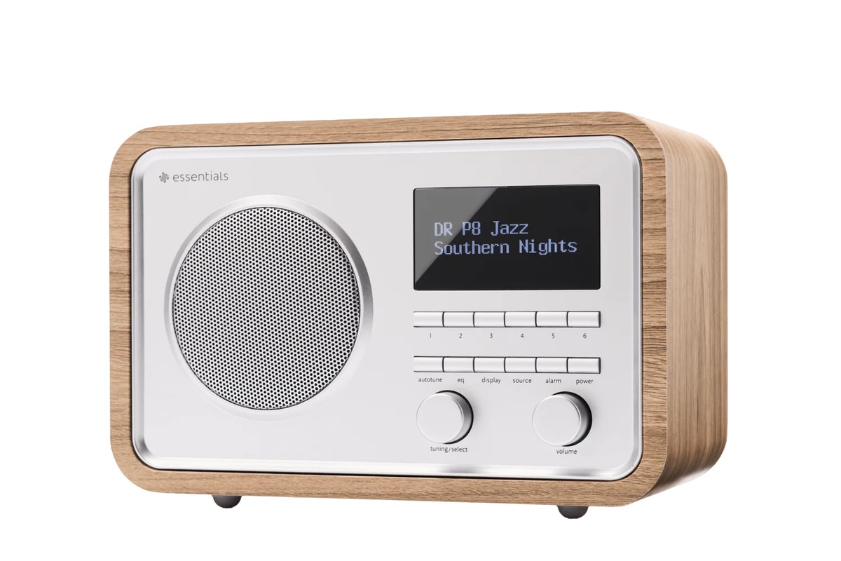 Radio compacte en finition frêne, façade argentée et écran OLED, vue de trois quarts