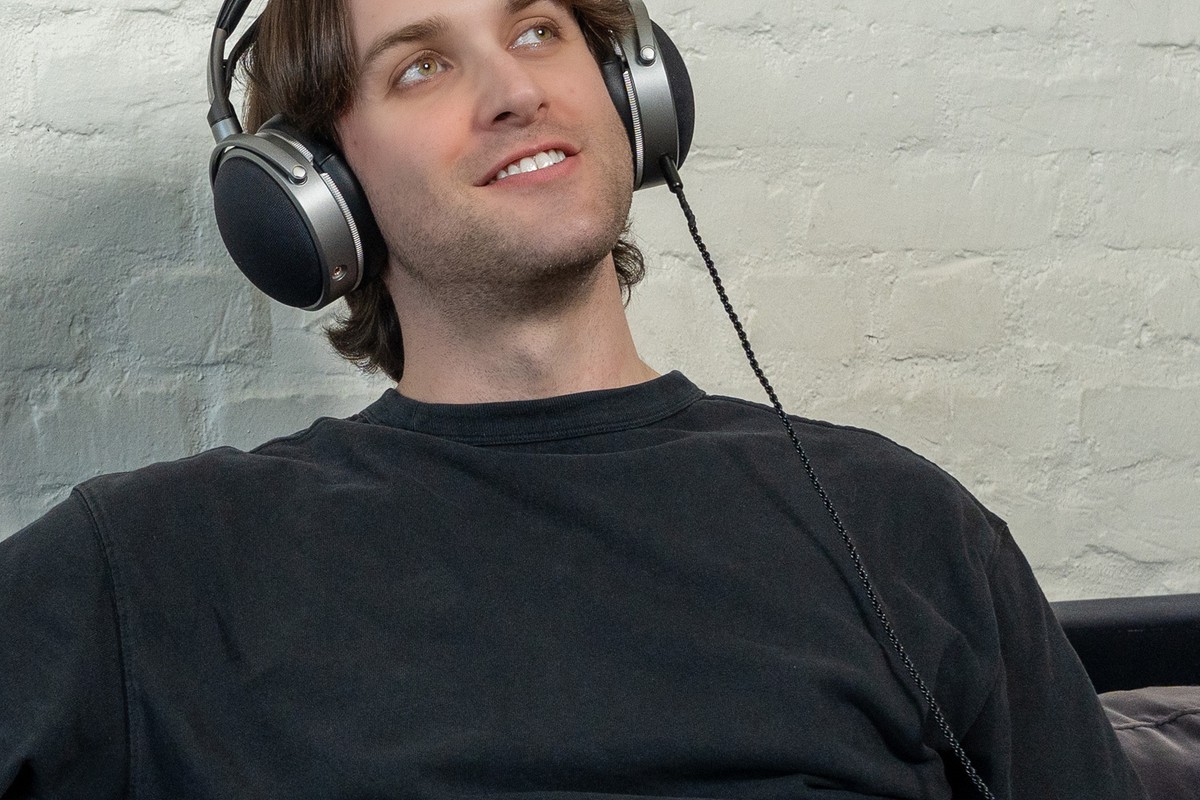 Homme portant le casque fermé Audeze LCD-S20 assis dans un salon