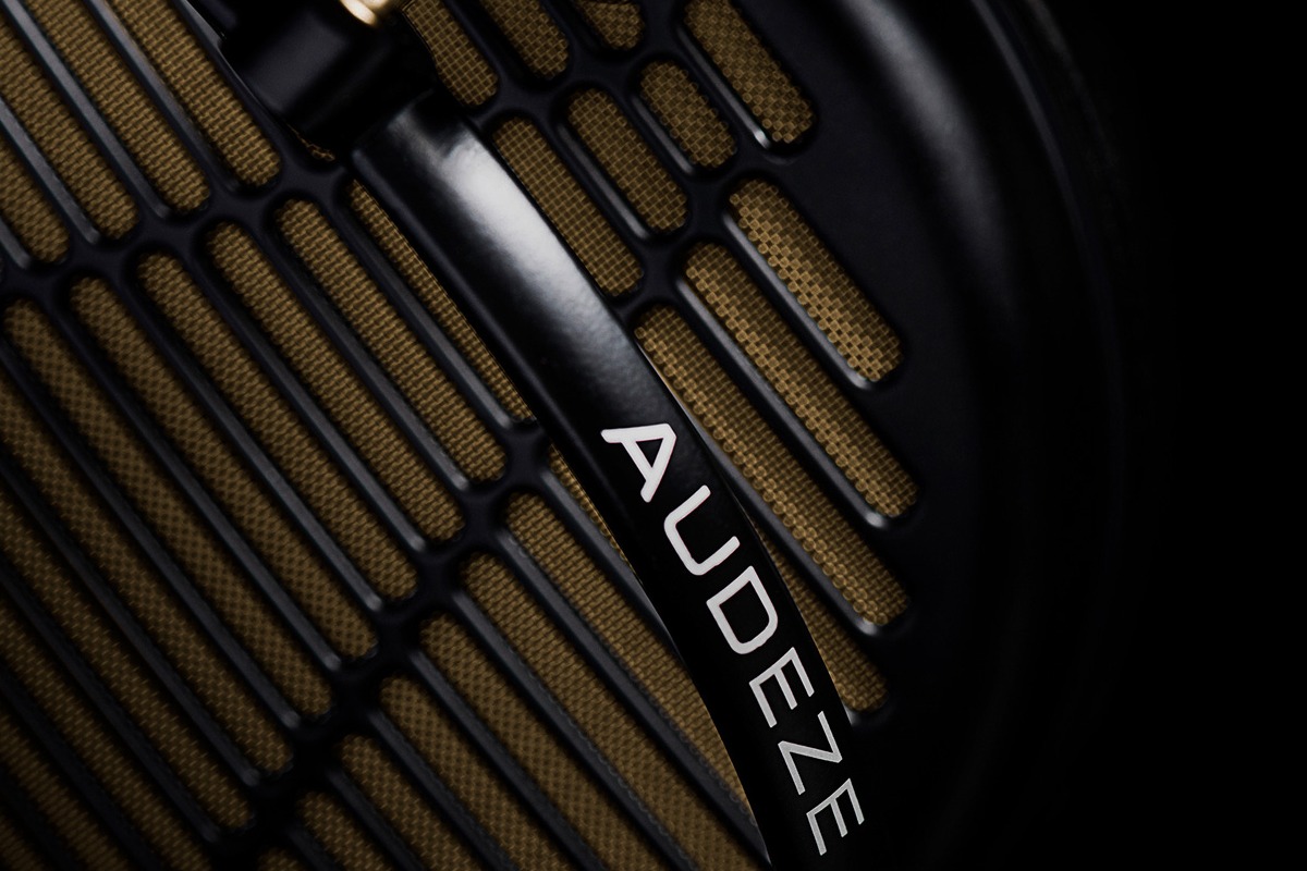 Vista macro della griglia dorata e del logo Audeze sul padiglione
