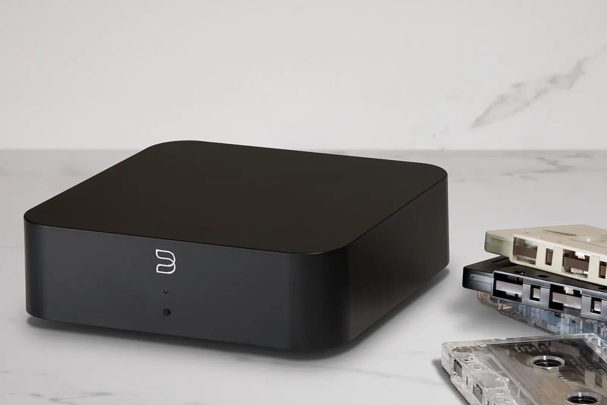 Boîtier noir posé sur un plan en marbre, à côté de cassettes audio