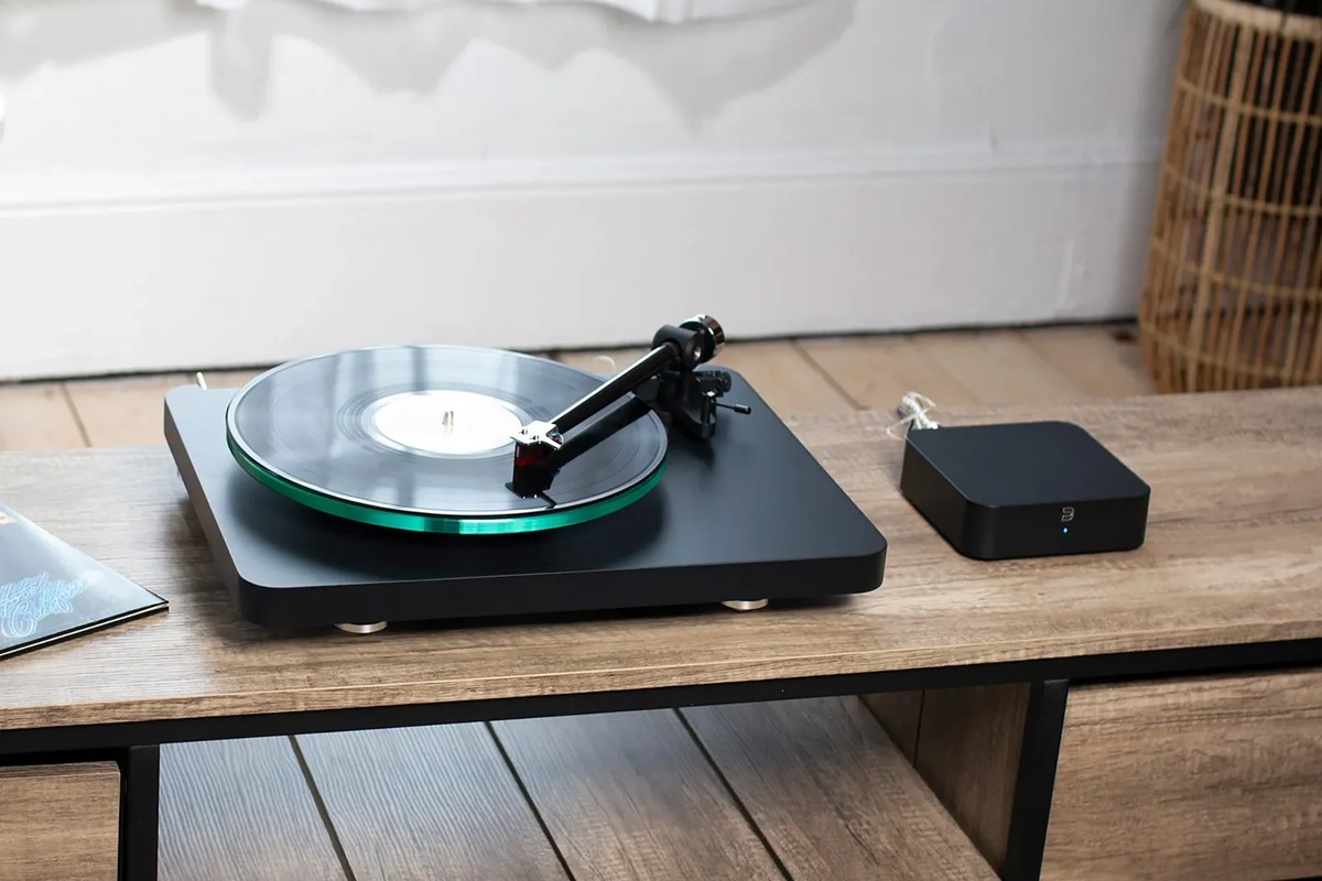 Platine vinyle et boîtier posés sur une table basse en bois