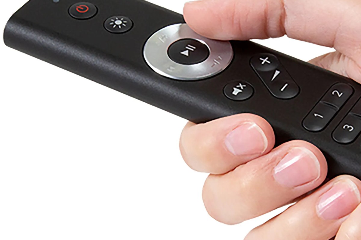 Télécommande tenue en main, pouce sur la molette centrale