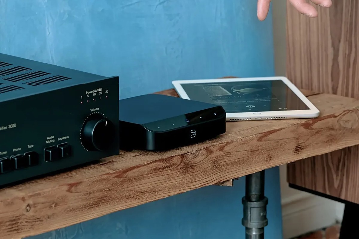 Streamer nero su un mobile in legno davanti a un amplificatore vintage