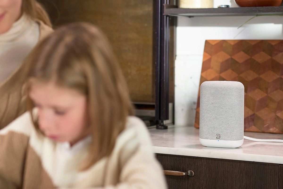 Enceinte blanche dans une cuisine, en fond d'une scène de vie