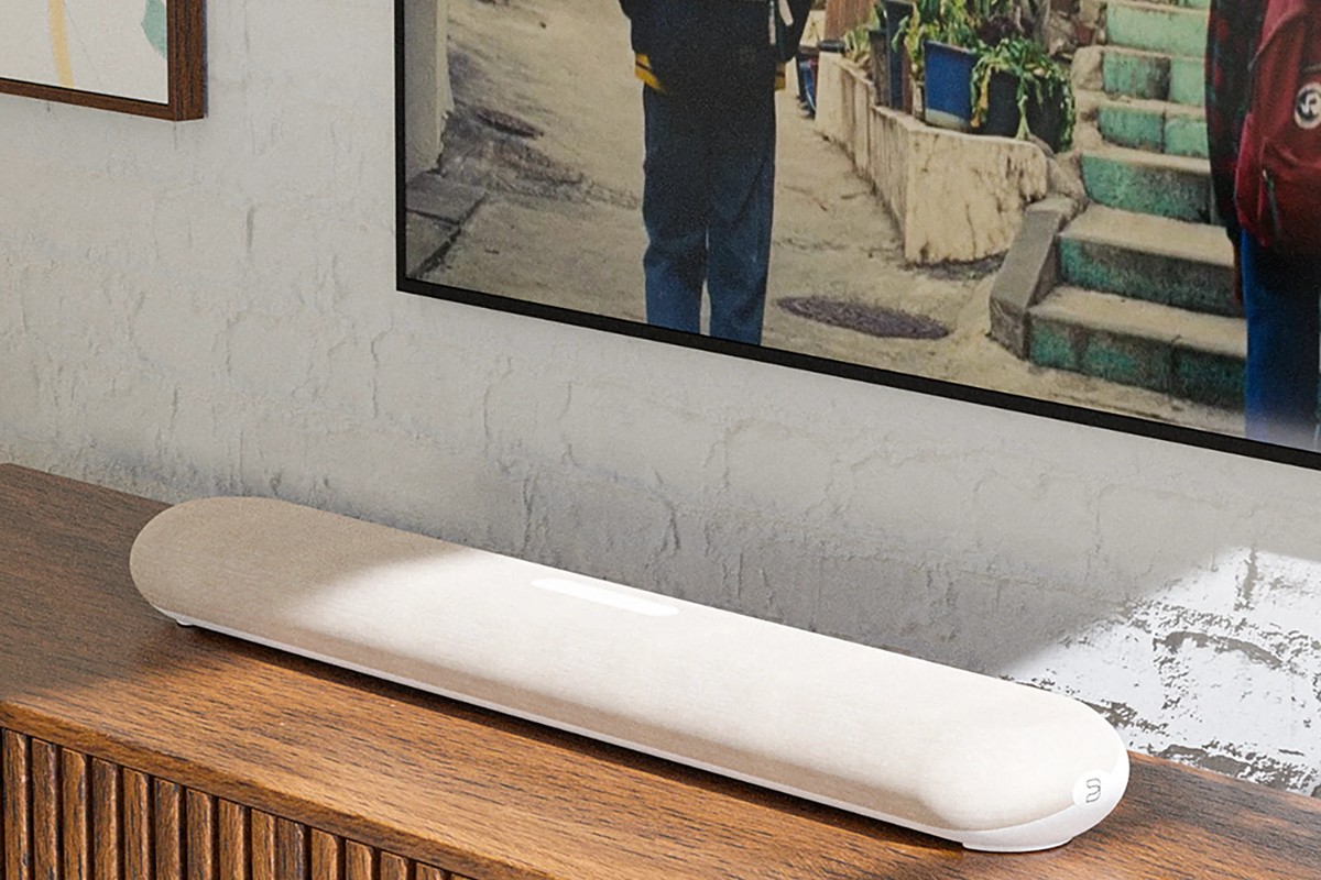 Modèle beige posé sous un écran, dans un salon clair