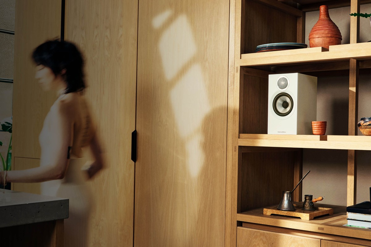 Enceintes Bowers & Wilkins 607 S3 posées sur une étagère en bois dans un salon