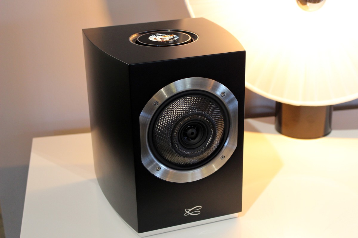 Satin black speaker seen at three quarters, aluminium-ringed coaxial and screen on top