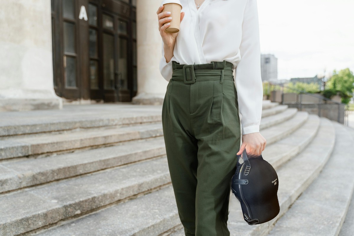 Woman walking down steps, the black sphere tucked in its carrying bag