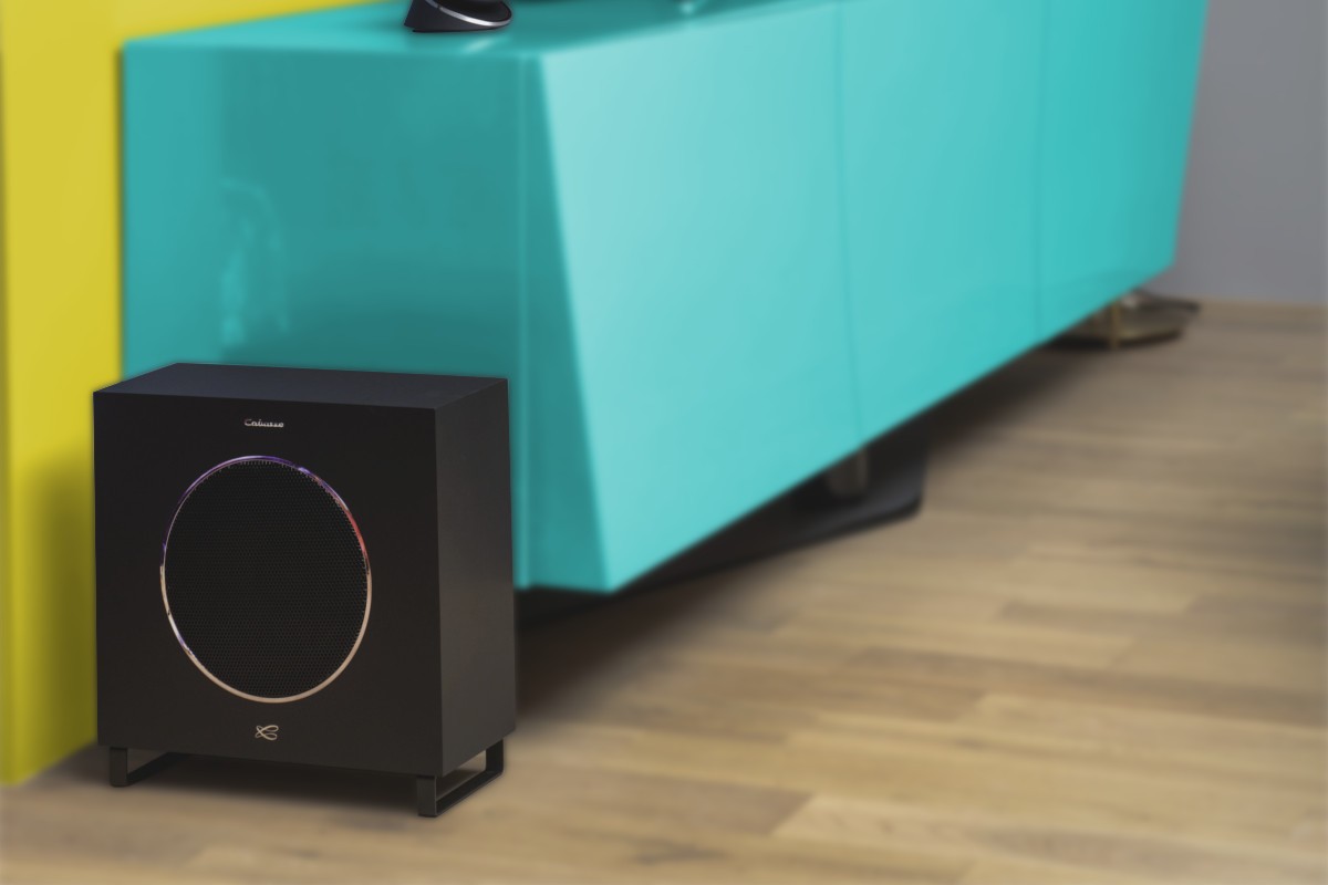 Subwoofer nero ai piedi di un mobile turchese, anello metallico intorno alla griglia