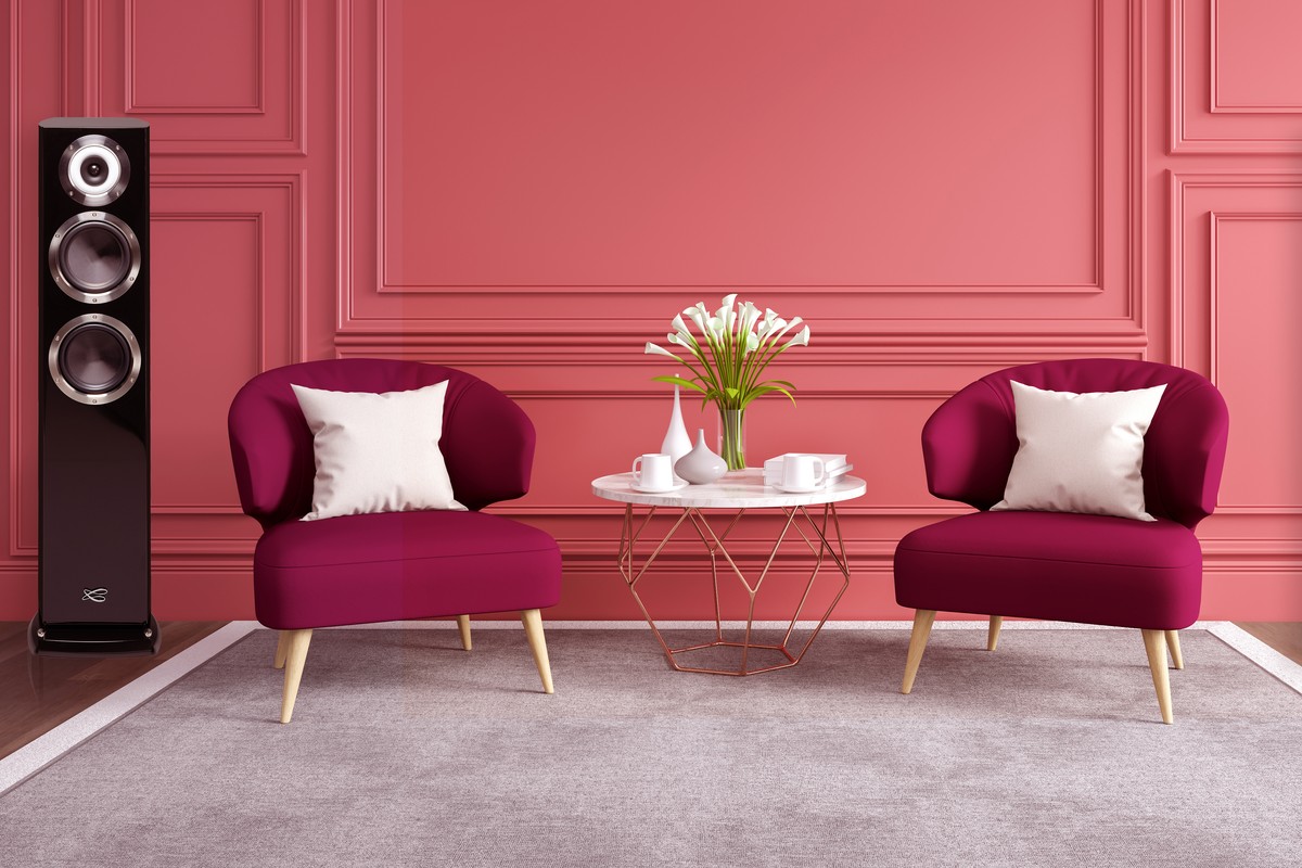 Black column near two raspberry armchairs in front of a pink wall