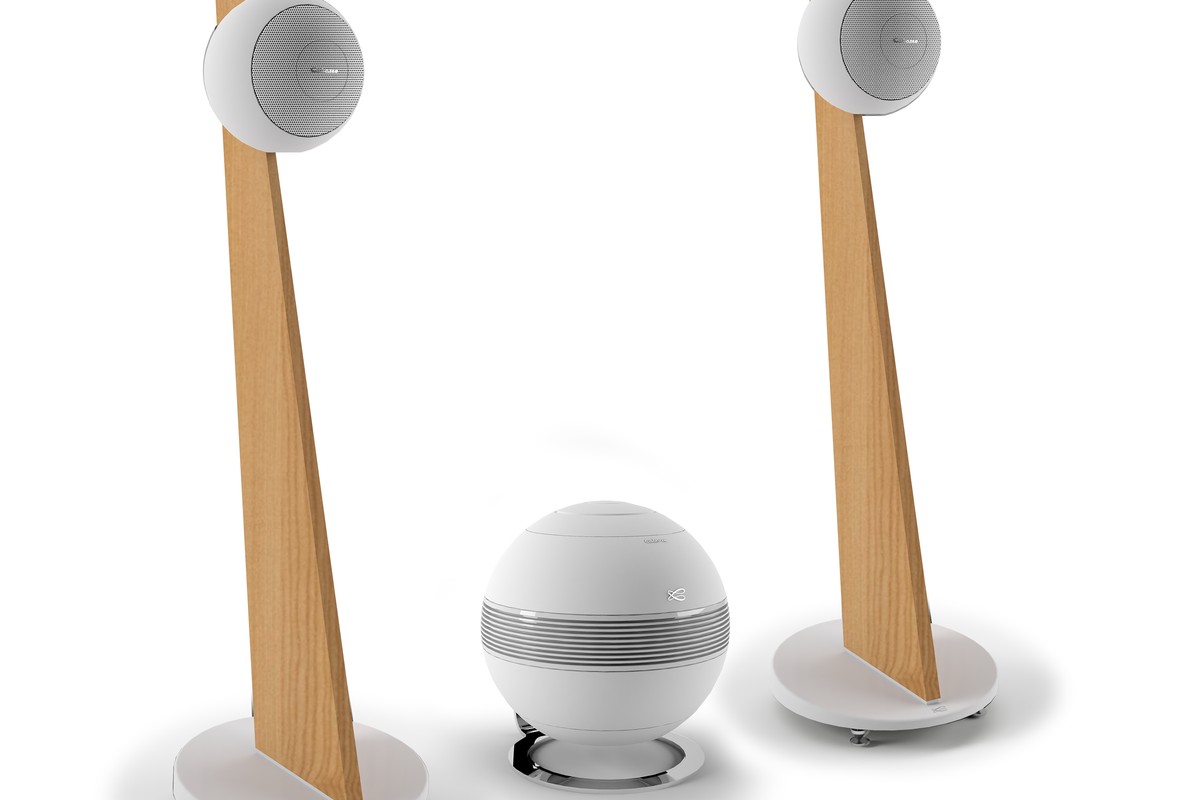 Due piedistalli Riga 2 in rovere con le loro sfere bianche, subwoofer The Pearl bianco al centro