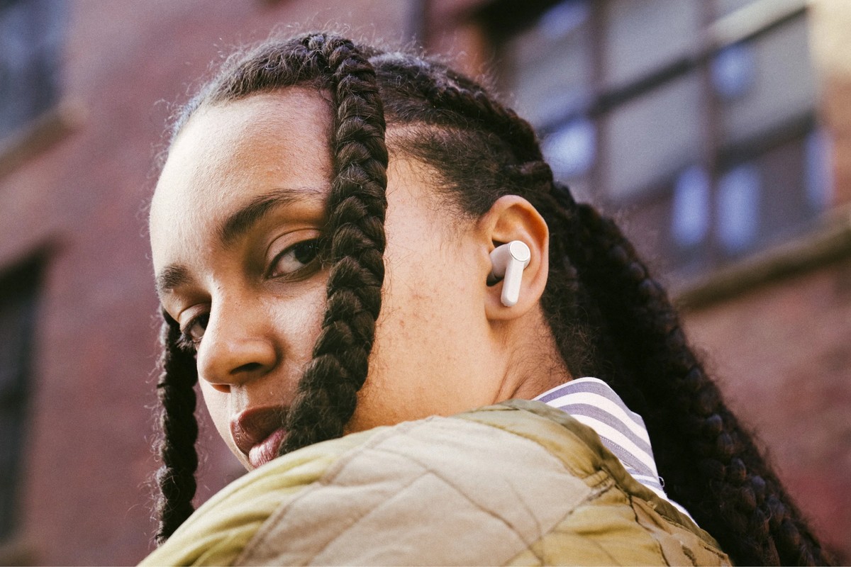 Jeune femme avec un écouteur blanc dans l'oreille