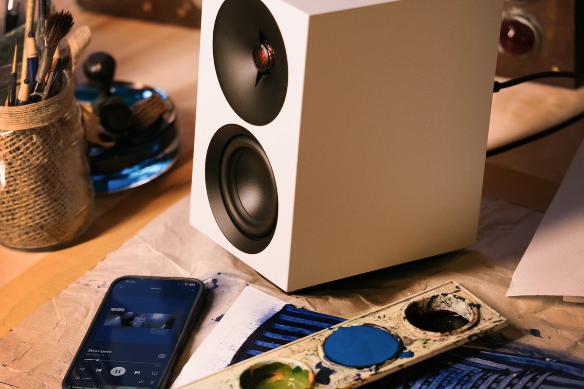 Diffusore bianco su un tavolo, con uno smartphone che riproduce musica