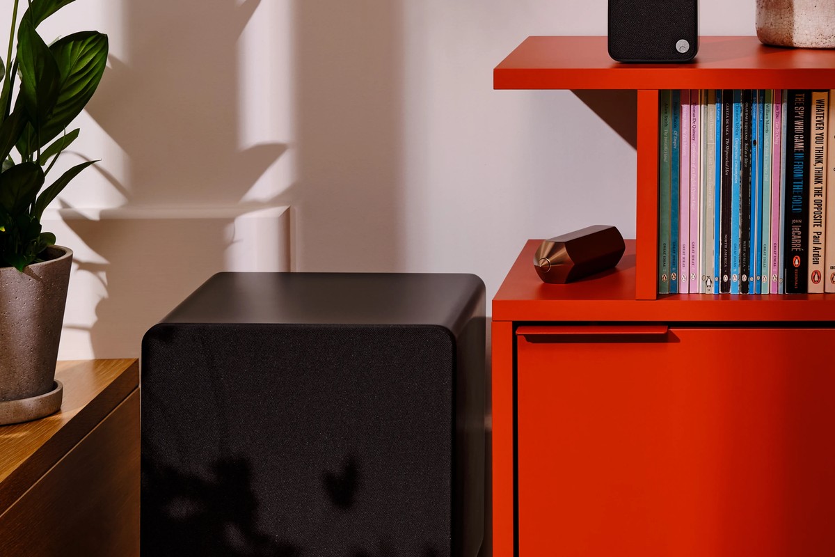 Subwoofer MSX Sub 300 nero vicino a un mobile rosso in un soggiorno