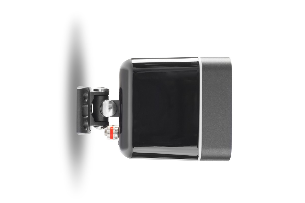 Black support fixed behind a compact speaker