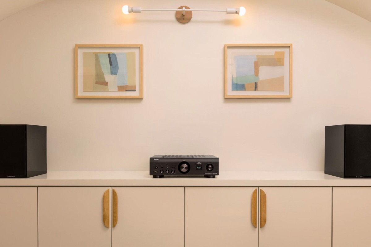 Amplificateur intégré posé sur un meuble bas dans un salon