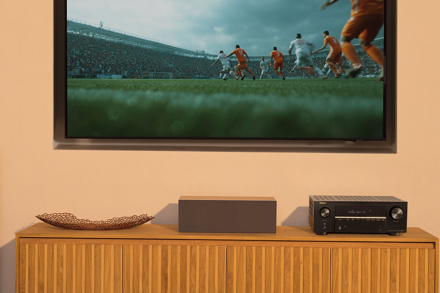 Salon home cinéma avec ampli-tuner noir sous un grand téléviseur