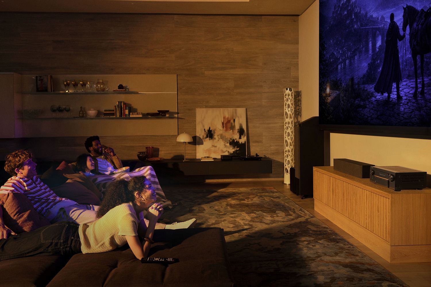 Family lying in front of a large projection screen, AV amplifier on a wooden cabinet