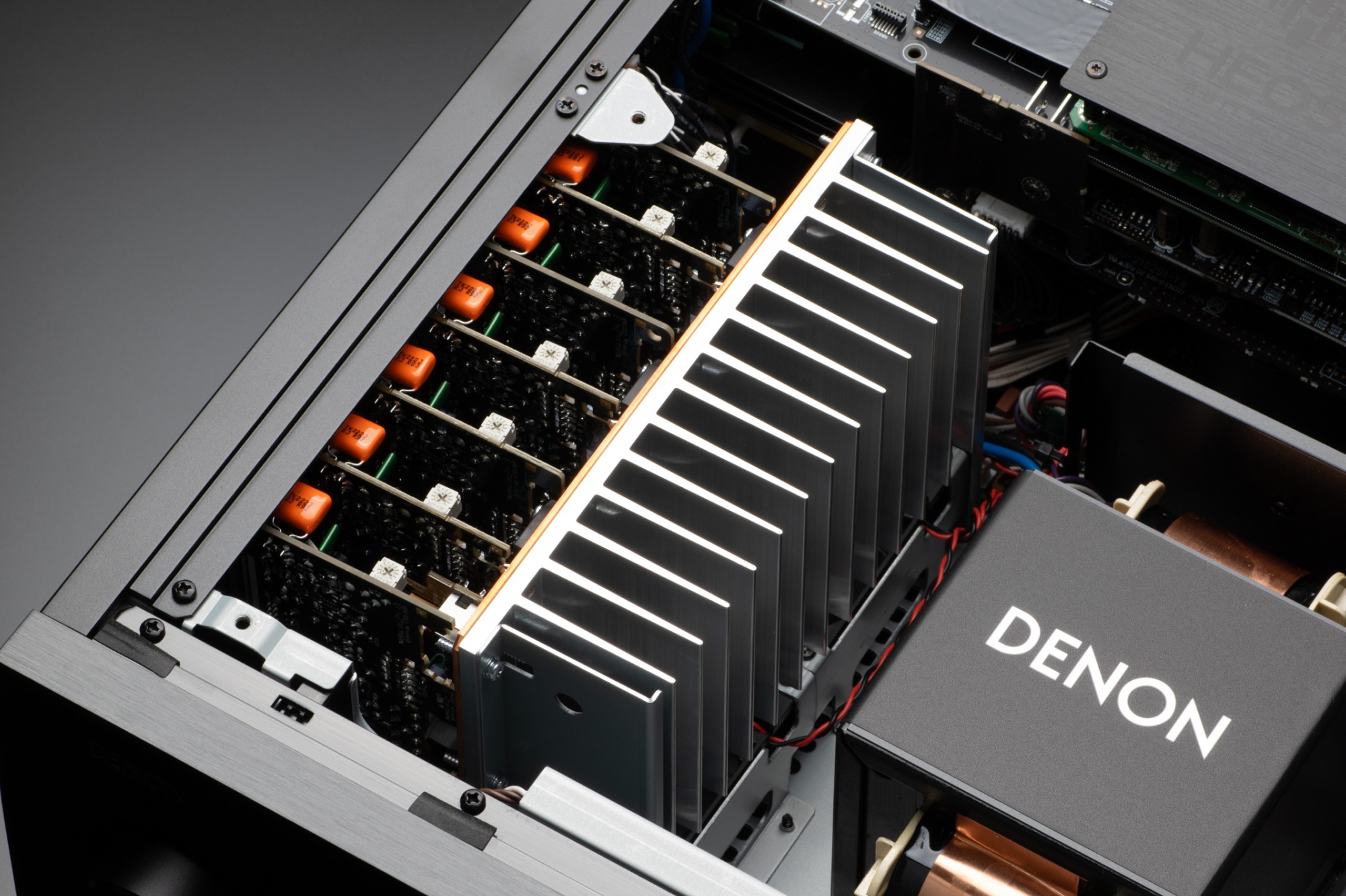 Intérieur d'un amplificateur AV : modules de canaux, dissipateur et transformateur