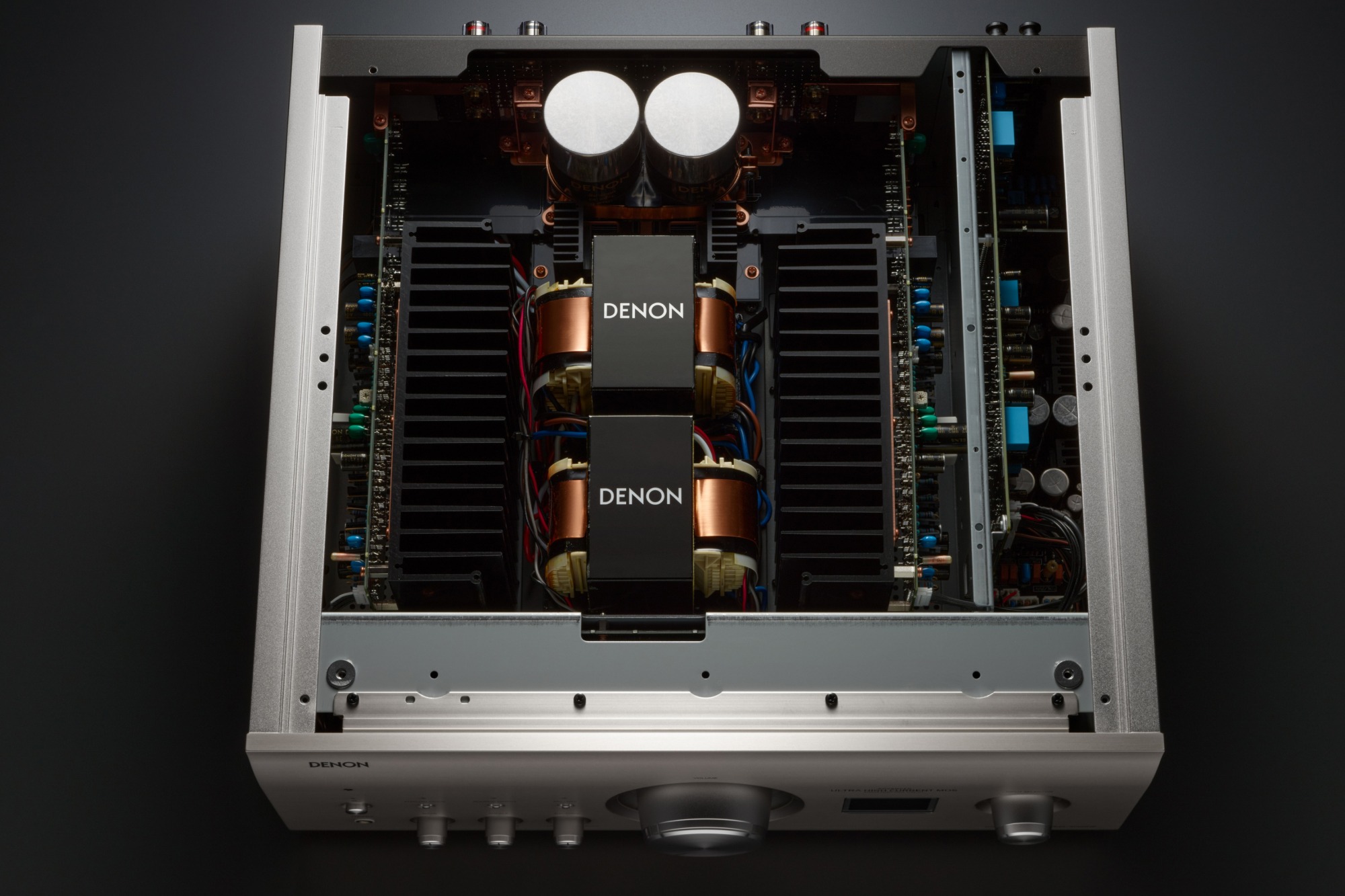 Open silver amplifier seen from above: transformers, heatsinks and circuits