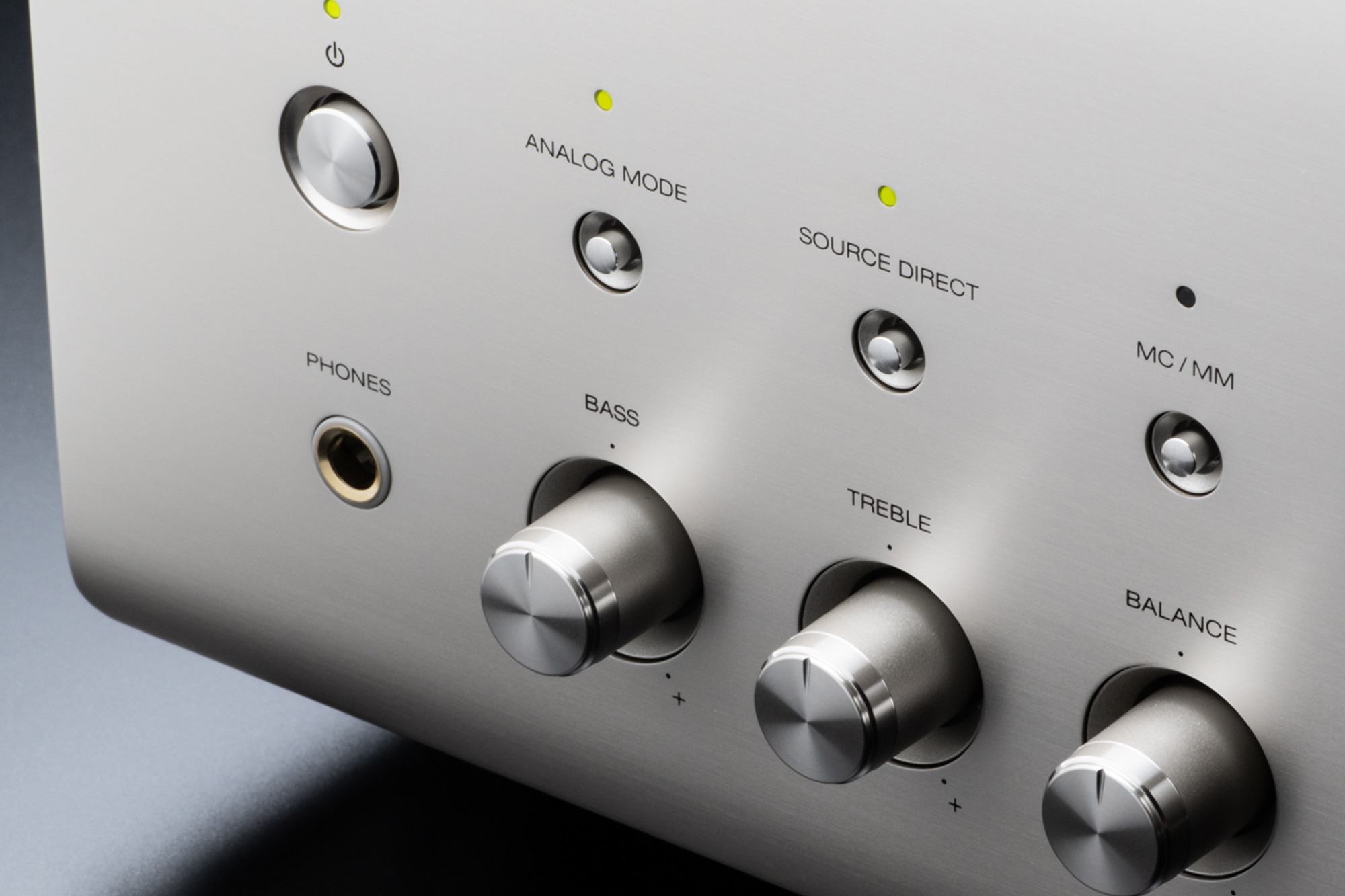 Close-up of a silver amplifier front panel with its selector buttons