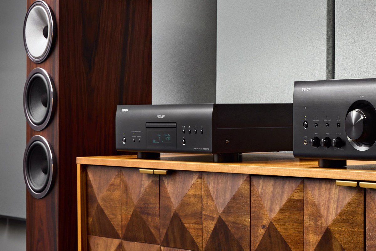 Lettore SACD nero e amplificatore abbinato su una credenza in legno, diffusore da pavimento accanto