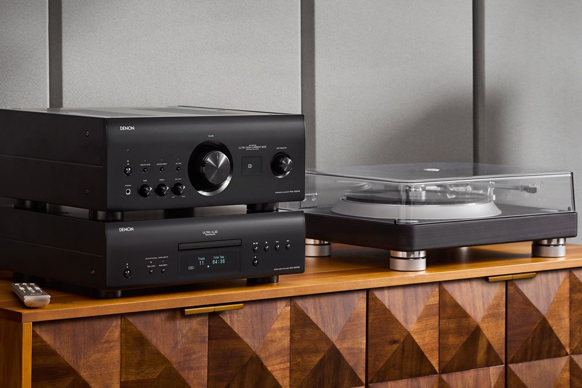 Amplificatore nero appoggiato sul lettore SACD abbinato, giradischi accanto su una credenza