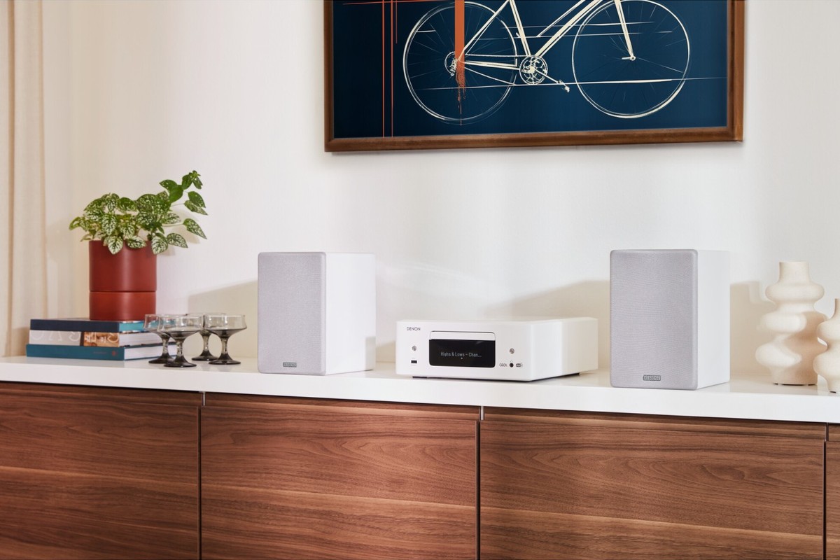 White micro system and its two speakers on a wooden sideboard