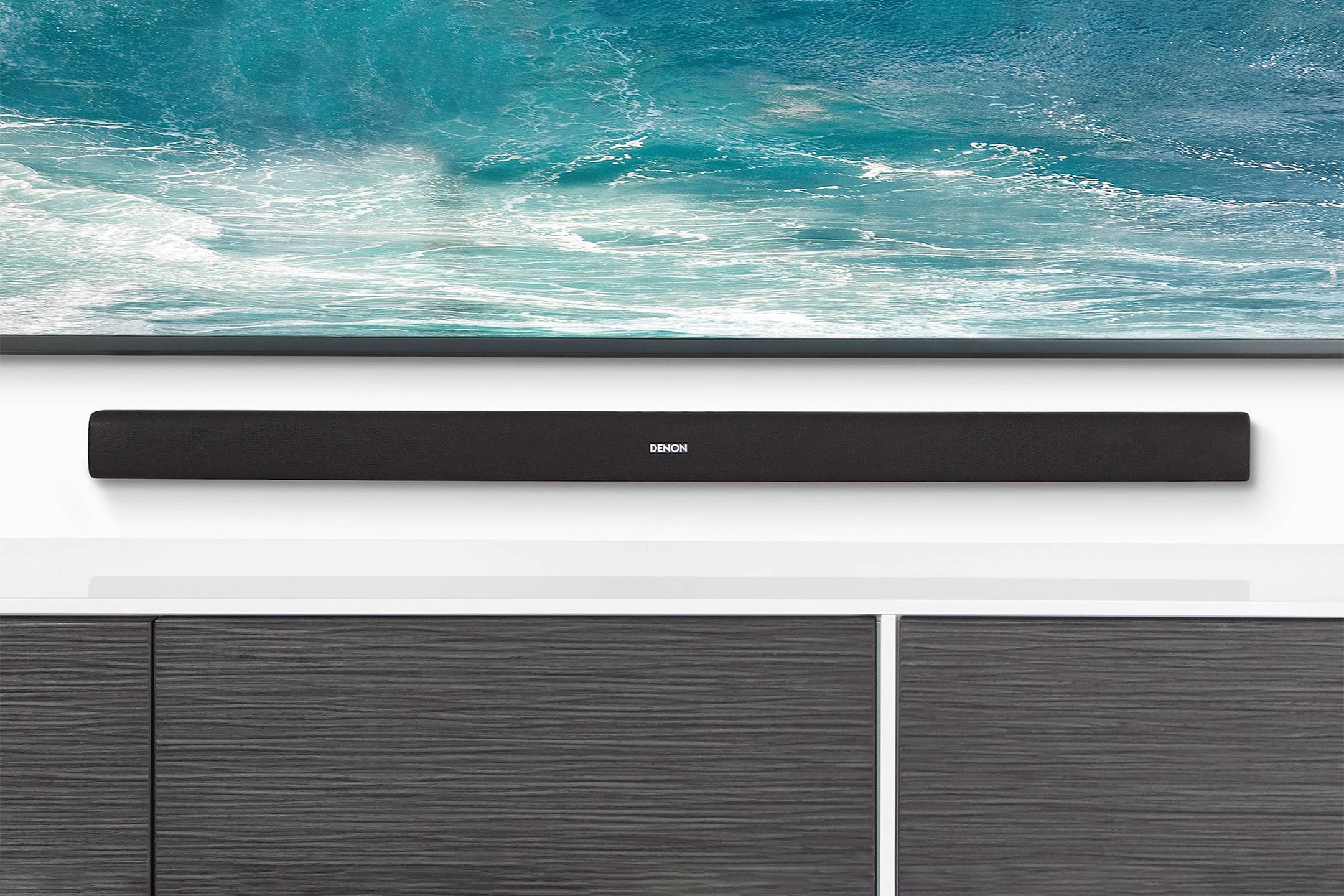 Soundbar sottile davanti a un televisore su un mobile basso