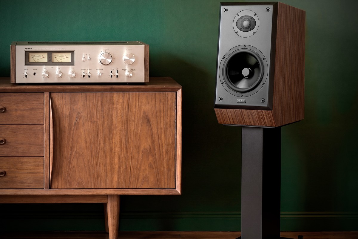 Walnut finish loudspeaker on a stand next to a vintage amplifier