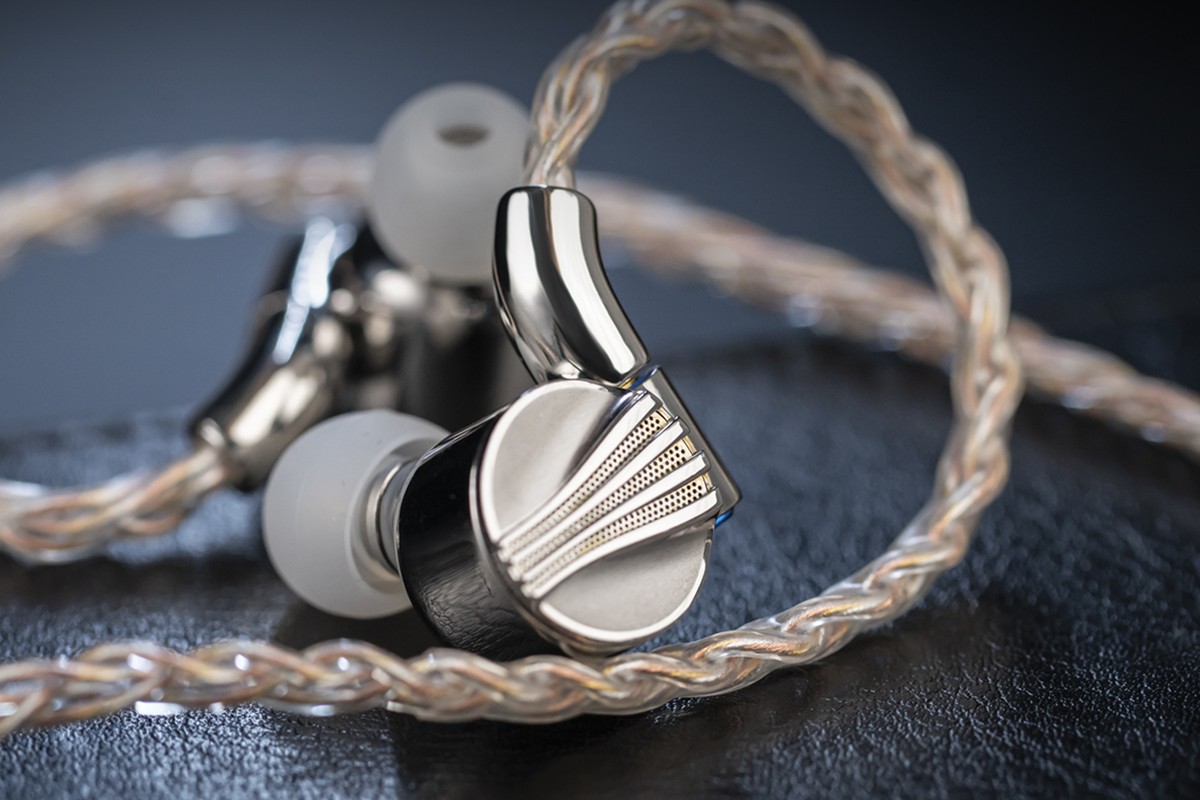 Auricolari in-ear appoggiati su pelle, cavo intrecciato e connettore MMCX angolato