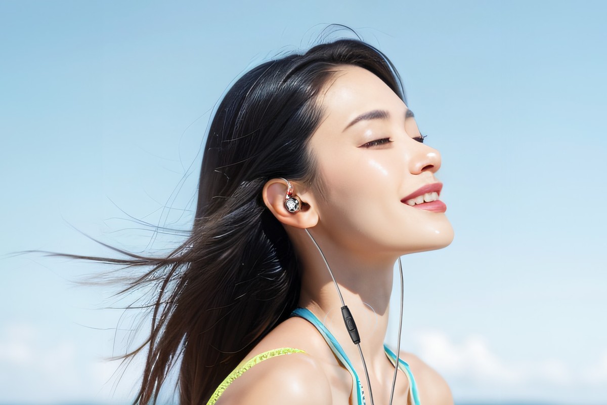 Femme de profil portant des écouteurs intra-auriculaires branchés sur le câble
