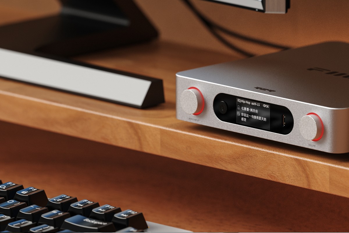On a desk, connected to headphones and a laptop