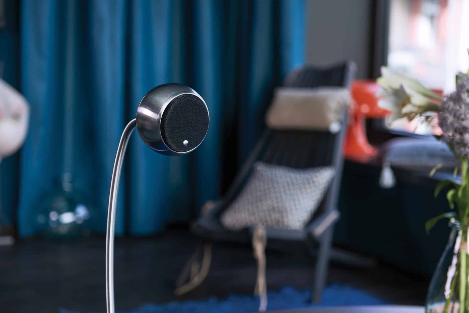 Enceinte sphérique argentée sur pied col de cygne dans un salon